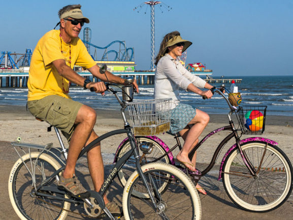 Couple riding bikes on Galveston Seawall a must-visit biking trail on the Upper Texas Coast